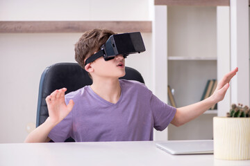 Schoolboy wearing virtual glasses at home