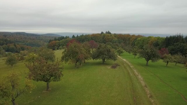 Ascending over beautiful mountainous area with dirt road during foogy fall season, Germany.