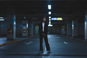 夜の街にいるスーツの女性