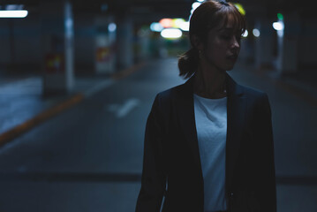 夜の街にいるスーツの女性