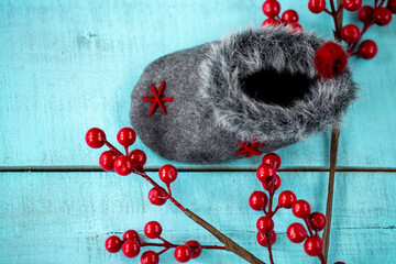 Christmas decoration sock, red berries on wooden background