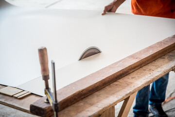 Furniture technician using Circular saw to cut wood make furniture.