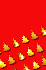 Set of shiny golden Christmas tree toys in form of xmas tree, New Year pattern on red background.