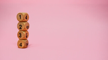 Wooden dice on pink background