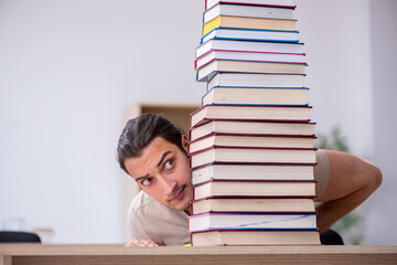 Young male student preparing for exams at library