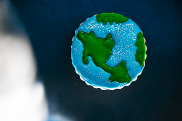 Gingerbread figure cookie with icing, hand painted. In the shape of a world with stars background...