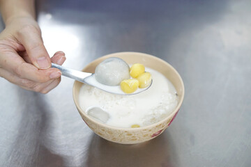 Black sesame dumplings (Sticky rice balls) with ginkgo nuts in iced fresh milk, Healthy and fusion dessert.