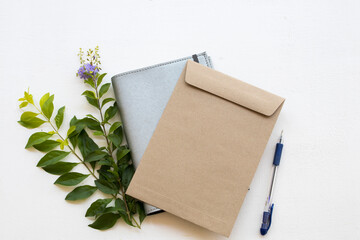 notebook planner with document envelope for business work with flower arrangement on background  white at office desk