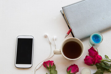 notebook planner ,hot coffee ,mobile phone of lifestyle woman for business work in winter season on background wooden
