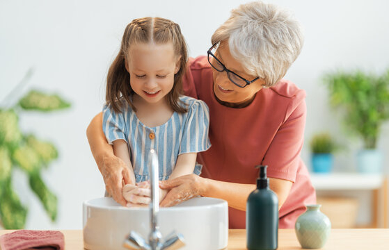 girl and her grandmother are washing hands