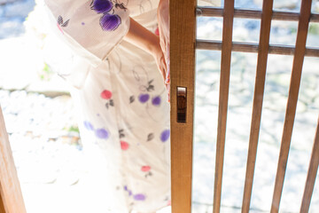 引き戸を開ける浴衣の女性