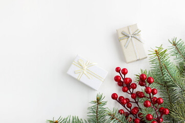 Christmas composition. Gifts, branches of blue spruce, red berries on a white background. Christmas, winter, new year concept. Flat lay, top view, copy space. Banner
