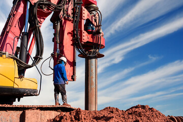 excavator drilling truck with workers in construction site on sky background