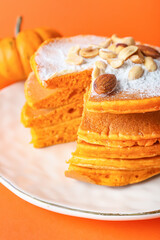 Plate with tasty pumpkin pancakes on color background, closeup