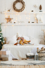 cozy New Year's children siblings in knitted hats and sweaters, gentle home photos of children, the concept of New Year and Christmas