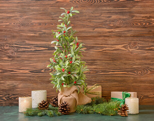 Beautiful Christmas composition with mistletoe plant on wooden background