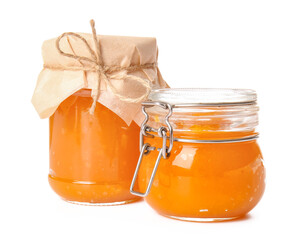 Jars of tasty pumpkin jam on white background