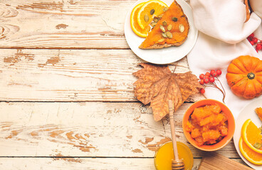 Autumn composition with tasty pumpkin jam on wooden background