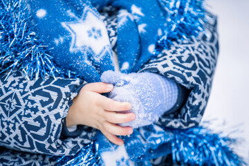 Hand of a small child is on the background of a blue Christmas winter suit.