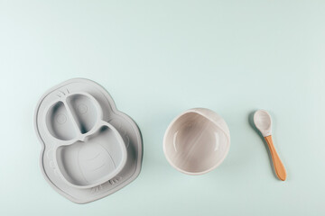 Grey silicone dishware on background. Serving baby, first feeding concept. Flat lay, copy space
