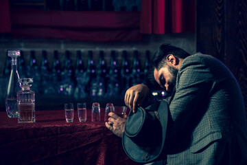 Drunk man holding glass. Client of beer pub sleeping and lying with his head on table. Concept of alcohol abuse and addiction.
