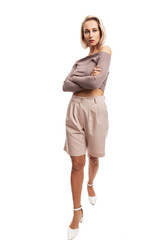 Serious young blond woman in pink suit. Full height. Isolated on white background. Vertical.