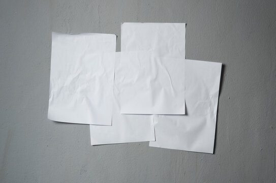 Empty old wrinkled white A4 paper stick on gray cement wall, changeable background. white paper note on gray © showcake