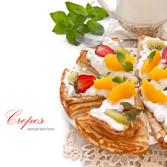 Crepes with soft cream, strawberries, kiwi, oranges and mint