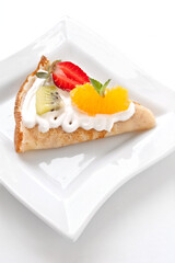 Crepes with soft cream, strawberries, kiwi, oranges and mint
