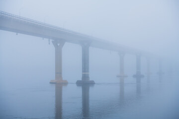 Bridge over the river in heavy fog