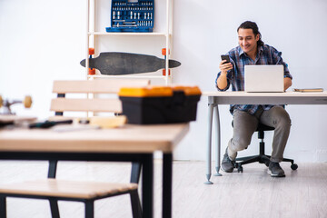 Young man repairing skateboard at workshop