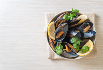 Mussels with herbs in a bowl with lemon