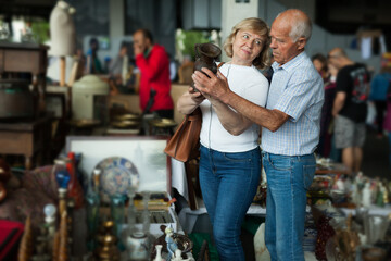 Elderly family choose handmade vase at flea market. High quality photo