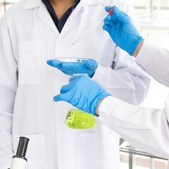 Science, Chemistry, Technology, Biology and Laboratory concept - A Picture of the hand of two scientists are testing an experiment result in a petri dish in their laboratory.
