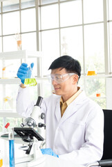 Science, Chemistry, Technology, Biology and Laboratory concept - A Picture of senior Asian scientists is considering an experiment result in glass flask in his laboratory.