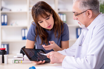 Fototapeta premium Young woman visiting old doctor radiologist