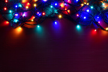 Christmas lights background with copy space. Glowing colorful Christmas lights on red grunge background. New Year. Multi color lights for decorate event.