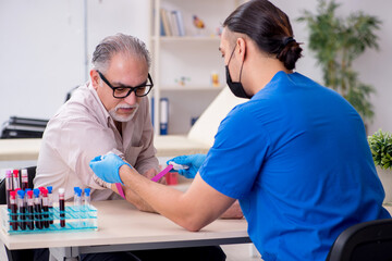 Obraz premium Old patient visiting young male doctor in blood transfusion conc