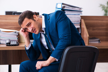 Young male employee unhappy with excessive work in the office