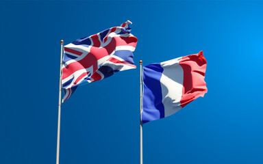 Beautiful national state flags of France and UK together at the sky background. 3D artwork concept.