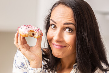 Guilty looking female has bitten off a doughnut