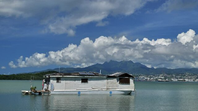 Floating tiny house overwater in Martinique with mountains in background For de France les pitons du carbet