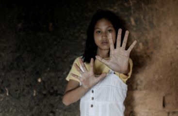 Concept of domestic violence and child abuse.Little girl showing STOP gesture with her hand.