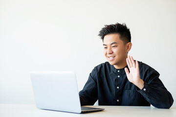 Online interview. Virtual meeting. Business webinar. Cheerful asian guy greeting team on laptop camera smiling isolated on white copy space background.