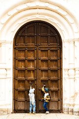 Curious little boys trying to open big aincient door.