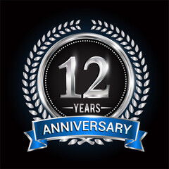 Birthday celebration logo 12th years with wreath, laurel, blue ribbon and silver ring.