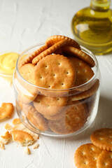 Glass jar with crackers, sauce and oil on white table