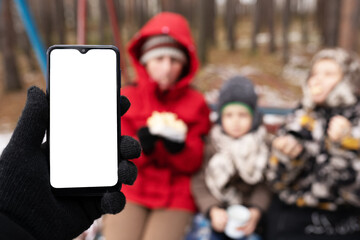 Fototapeta premium hand in gloves holding phone outdoors