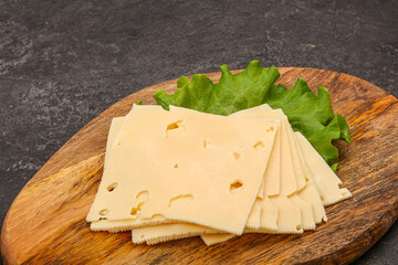 Sliced yellow cheese over board