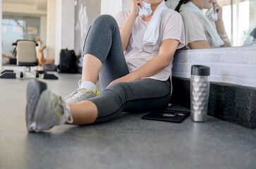 Asian woman workout and working online alone at GYM. Social distancing and new normal lifestyle.
